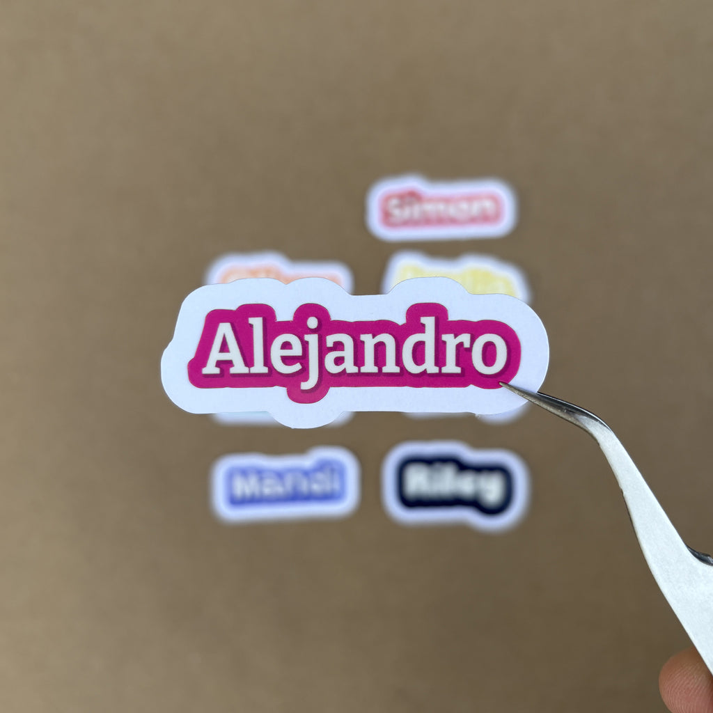 A close-up scale shot showing a 2-inch green "Alejandro" sticker, illustrating how the height varies naturally with the name length while maintaining a consistent 2-inch width.